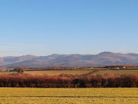 A scenic view of mountains and fields at Gate House Capel Coch near Llanerchymedd