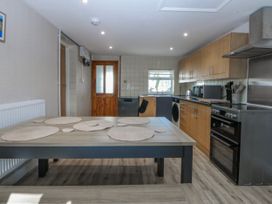 A kitchen with a table and kitchen appliances at Gate House Capel Coch near Llanerchymedd