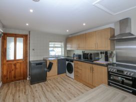 A kitchen with appliances and cabinets at Gate House in Capel Coch near Llanerchymedd