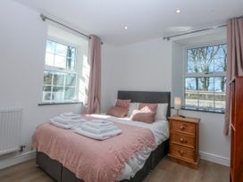 A bedroom with a bed and bedside table at Gate House near Capel Coch near Llanerchymedd