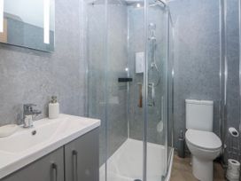 A bathroom with a shower and wash basin at Gate House in Capel Coch near Llanerchymedd