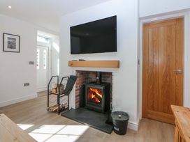 A living room with a fireplace and TV at Gate House Capel Coch near Llanerchymedd