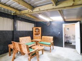 A snug with wooden seating and a small bathroom area at Gate House Capel Coch near Llanerchymedd