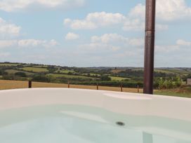 A hot tub overlooking a rural landscape at The Cadeleigh near Tiverton