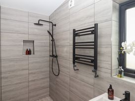 A bathroom with a shower, towel rail and soap dispenser at The Cadeleigh near Tiverton