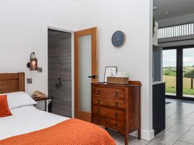 A bedroom with a bed and wooden furniture at The Cadeleigh near Tiverton