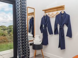 A bathroom with bathrobes and towels at The Cadeleigh near Tiverton
