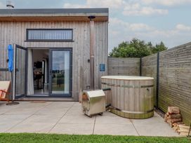 An outdoor area with a hot tub and patio furniture at The Cadeleigh in Cadeleigh near Tiverton