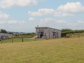A house with a deck and chairs in a grassy area at The Cadeleigh near Tiverton