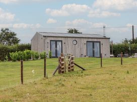 A house with a wooden exterior and a fence at The Pennymoor in Cadeleigh near Tiverton