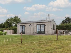 A house with wooden exterior and patio furniture at The Pennymoor Cadeleigh near Tiverton