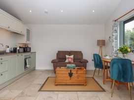 A living room with a sofa and kitchen unit at The Pennymoor in Cadeleigh near Tiverton