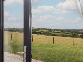 A view of hills and grass from an open door at The Pennymoor in Cadeleigh near Tiverton