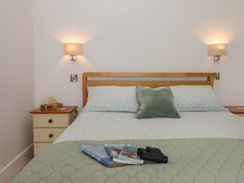 A bedroom with a bed and nightstand at The Pennymoor in Cadeleigh near Tiverton