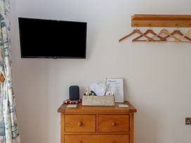 A bedroom with a television and a storage unit at The Pennymoor in Cadeleigh near Tiverton