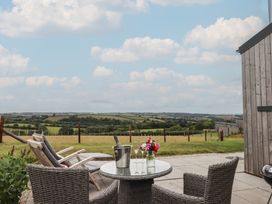 A seating area with a table and chairs overlooking the countryside at The Pennymoor in Cadeleigh near Tiverton