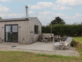 An outdoor area with a hot tub and seating at The Pennymoor in Cadeleigh near Tiverton