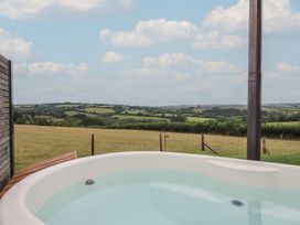 A hot tub on a wooden deck overlooking the countryside at The Bickleigh in Cadeleigh near Tiverton
