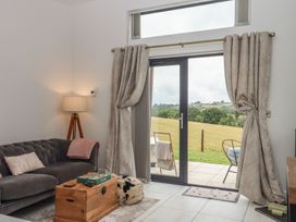 A living room with a sofa and door leading outside at The Bickleigh in Cadeleigh near Tiverton
