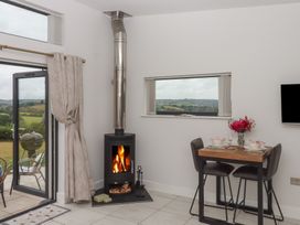 A dining area with a wood stove and table at The Bickleigh in Cadeleigh near Tiverton