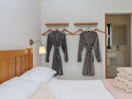 A bedroom with robes hanging on the wall and towels folded at The Bickleigh Cadeleigh near Tiverton