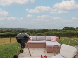 An outdoor seating area with a barbecue and sofa at The Bickleigh in Cadeleigh near Tiverton