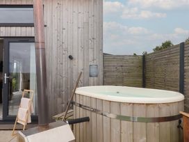 An outdoor area with a hot tub and a towel rack at The Bickleigh Cadeleigh near Tiverton