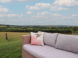 A couch with a pillow overlooking a landscape at The Bickleigh in Cadeleigh near Tiverton