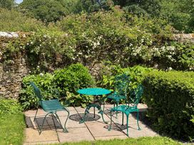 A garden with a table and chairs surrounded by plants at Greywalls in Maulds Meaburn
