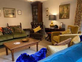 A living room with a green sofa and yellow armchair at Greywalls in Maulds Meaburn