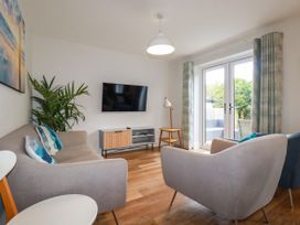 A living room with a television and seating area at Chi Gwynn in Crantock