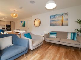 A living room with sofas and a dining table at Chi Gwynn in Crantock