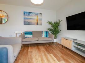 A living room with a sofa and TV at Chi Gwynn in Crantock