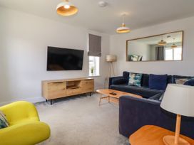 A living room with a sofa and television at Chi Gwynn in Crantock