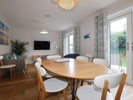 A dining room with a table and chairs at Chi Gwynn in Crantock