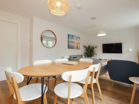 A dining area with a wooden table and chairs at Chi Gwynn in Crantock