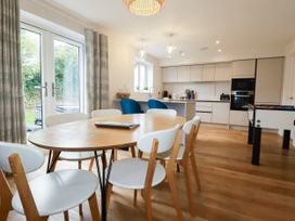 A kitchen with a dining table and chairs at Chi Gwynn in Crantock