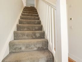 A staircase with carpet and a handrail at Chi Gwynn in Crantock