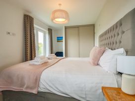 A bedroom with a bed and curtains at Chi Gwynn in Crantock