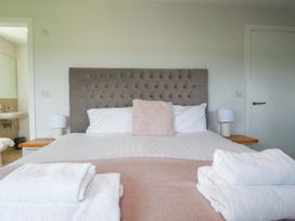 A bedroom with a bed and lamps at Chi Gwynn in Crantock
