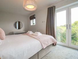 A bedroom with a bed and mirror at Chi Gwynn in Crantock