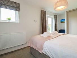 A bedroom with a bed and towels at Chi Gwynn in Crantock