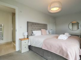 A bedroom with a bed and a nightstand at Chi Gwynn in Crantock