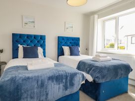 A bedroom with two beds and a window at Chi Gwynn in Crantock