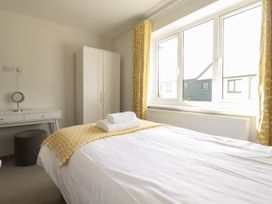 A bedroom with a bed and dressing table at Chi Gwynn in Crantock