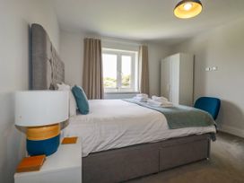 A bedroom with a bed and wardrobe at Chi Gwynn in Crantock