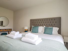 A bedroom with a bed and towels at Chi Gwynn in Crantock
