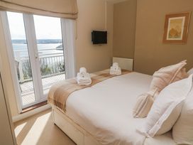 A bedroom with a bed and balcony view at Tremorna Vista in Carbis Bay