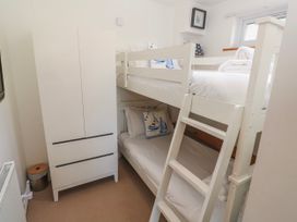 A bedroom with a bunk bed and wardrobe at Tremorna Vista in Carbis Bay