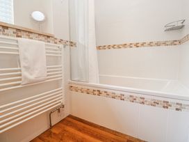 A bathroom with a bathtub and towel rack at Tremorna Vista in Carbis Bay